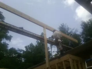 Carpenter setting a ridge beam over a new addition frame — Ice Dam Removal by Roofing Brothers in Damascus