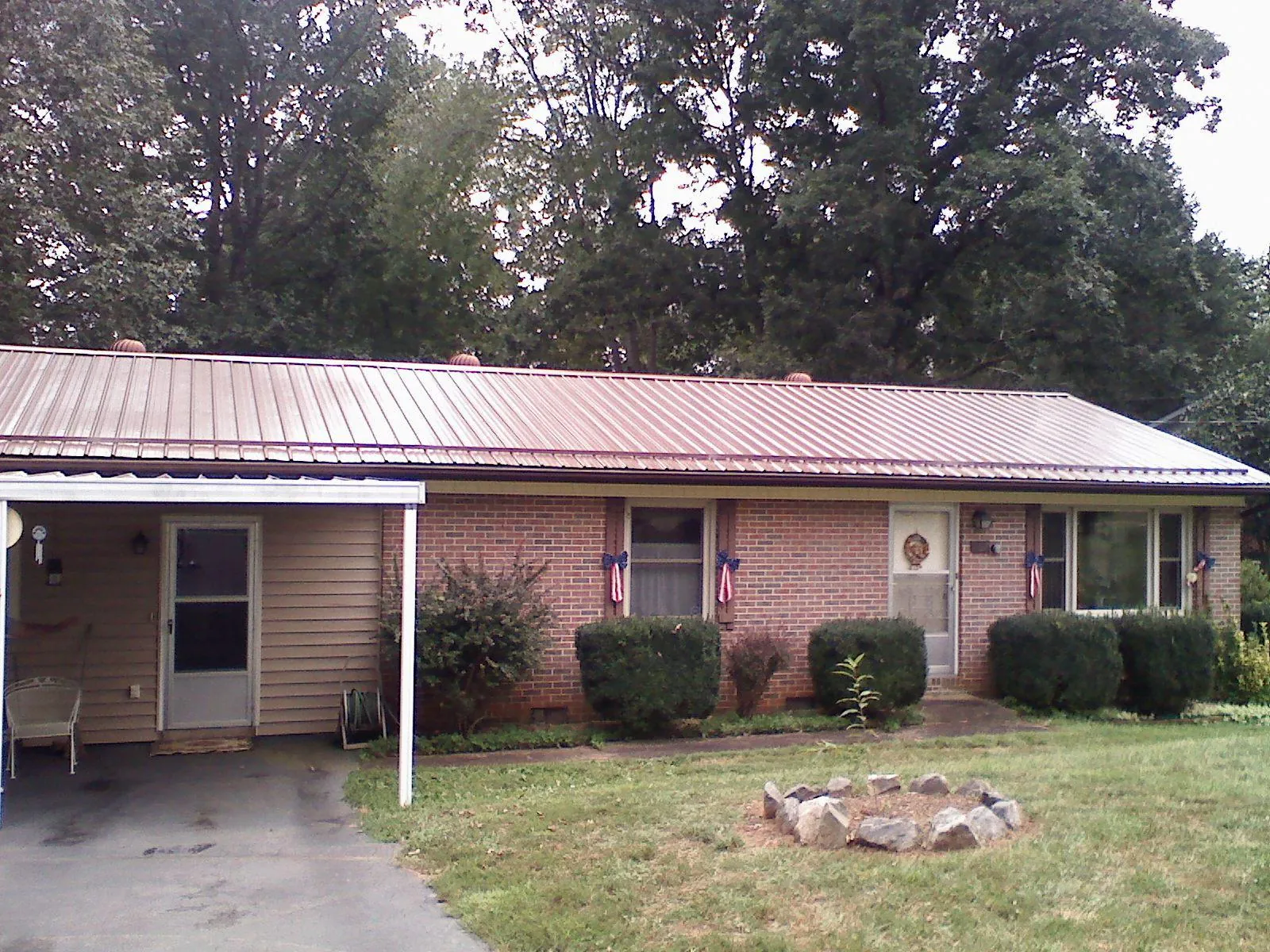 Bronze metal roof and carport on a brick ranch home — Roof Repair work by our crew in Damascus